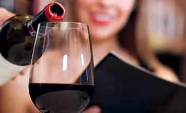 Человек наливает вино в бокал